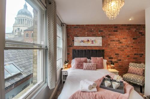 a bedroom with a bed and a brick wall at Spacious, Elegant City Centre Apartment with FREE WIFI in Nottingham