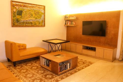a living room with a television and a chair at Surya Kiran Heritage Hotel in Panaji