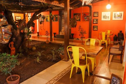 a dining room with orange walls and a table and chairs at Surya Kiran Heritage Hotel in Panaji