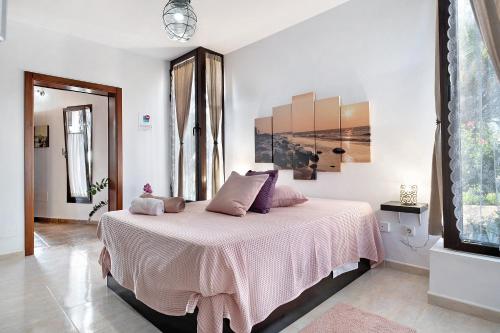 sypialnia z dużym łóżkiem i różowym kocem w obiekcie Casa Guenia I w mieście Teguise