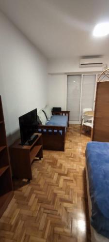 Dormitorio con cama, escritorio y TV en Departamento Subte linea B Ángel Gallardo en Buenos Aires