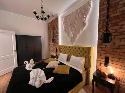 Brick Castle - Apartament Helga في فروتسواف: غرفة نوم مع سرير مع اثنين من الحيوانات المحشوة عليه