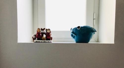 two figurines sitting on a window sill next to a vase at B&B Via dell'Azzurra in Bari