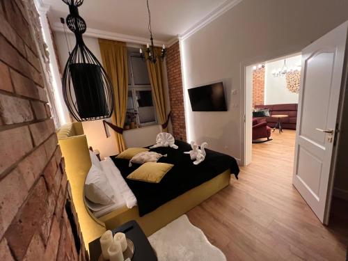 a bedroom with a bed and a living room at Brick Castle - Apartament Helga in Wrocław