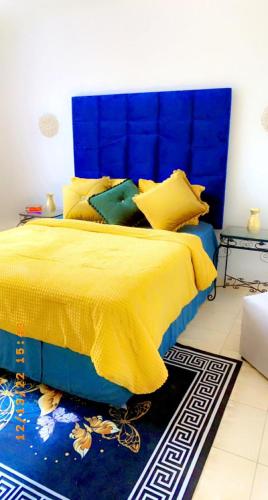 a bedroom with a yellow bed with a blue headboard at Ntindili Bed and Breakfast in De Deur