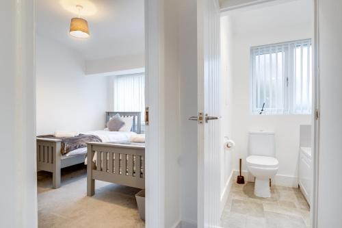a bathroom with a bed and a toilet in a room at 4 Bedroom House Near BHX, NEC & HS2 in Birmingham