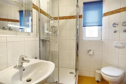 a bathroom with a sink and a shower and a toilet at Sonnenwinkel, FW 2 in Zingst