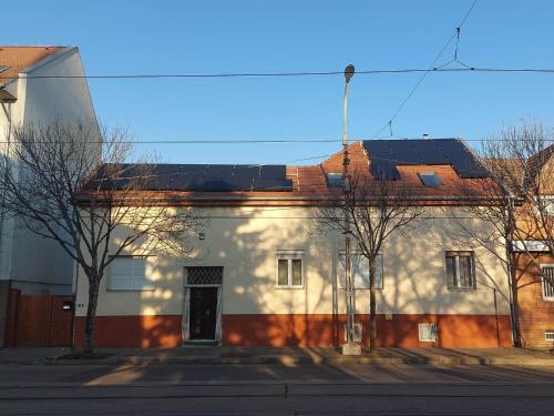 a white building with solar panels on top of it at Red Locomotive Apartment in Budapest