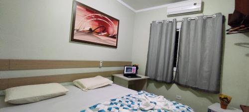 a bedroom with a bed and a television in it at POUSADA EVELINA in Foz do Iguaçu