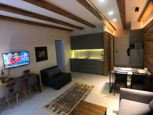 a living room with a couch and a table and a kitchen at Zen Apartments Gudauri in Gudauri