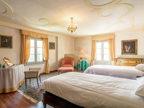 una camera con due letti, un tavolo e una sedia di Historic Venetian Style Castle in Piombino Dese with Pool a Piombino Dese