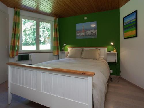 ストゥモンにあるAttractive holiday home in Stoumont with gardenの緑の壁のベッドルーム1室(大型ベッド1台付)