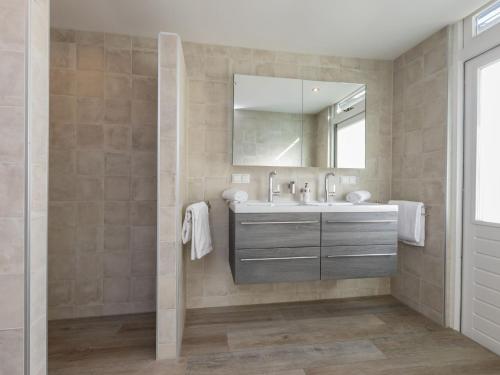 a bathroom with a sink and a mirror at Holiday Home in Zeeland Family-Friendly in Serooskerke
