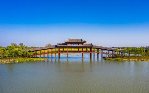a large building sitting on top of a body of water at Holiday Inn Fuyang by IHG in Fuyang