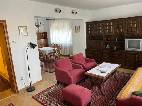 a living room with red chairs and a table at Vidikovac Vrnjačka Banja in Vrnjačka Banja