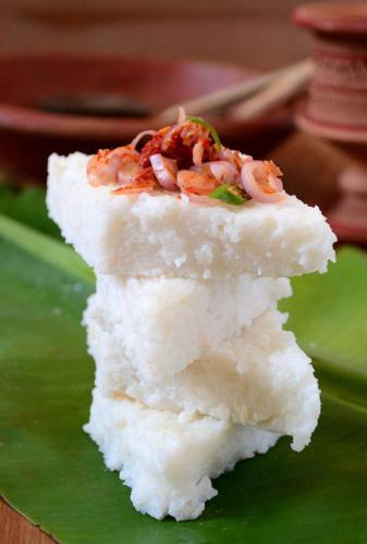 a piece of rice with shrimp on top on a green plate at Barefoot Inn Kandy in Kandy