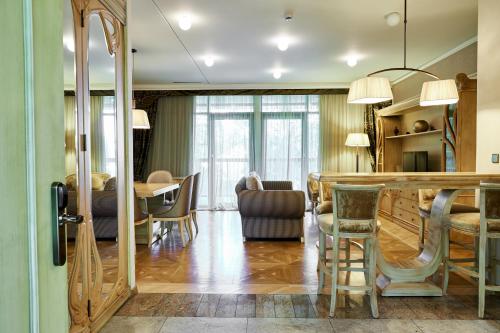 a kitchen and living room with a table and chairs at Grand SPA Lietuva Serviced Apartments Dzūkija in Druskininkai