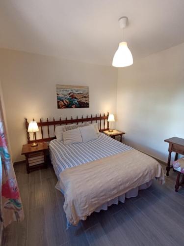 ein Schlafzimmer mit einem großen Bett und zwei Nachttischen in der Unterkunft Strelitzia in Puerto del Carmen