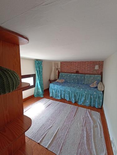 ein Schlafzimmer mit einem blauen Bett und einer Ziegelwand in der Unterkunft Strelitzia in Puerto del Carmen