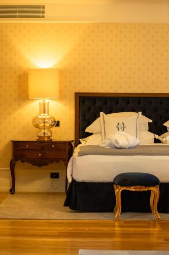a bedroom with a bed and a table with a lamp at Solar do Requeijo by Luna Hotels & Resorts in Arcos de Valdevez