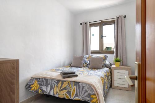 a small bedroom with a bed and a window at Casa Lía in La Santa