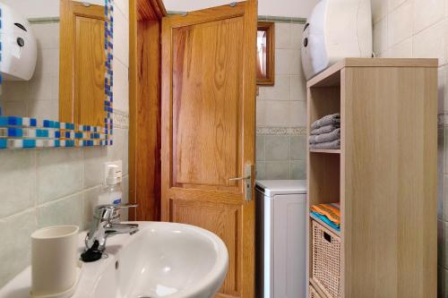 a bathroom with a sink and a wooden door at Casa Lía in La Santa
