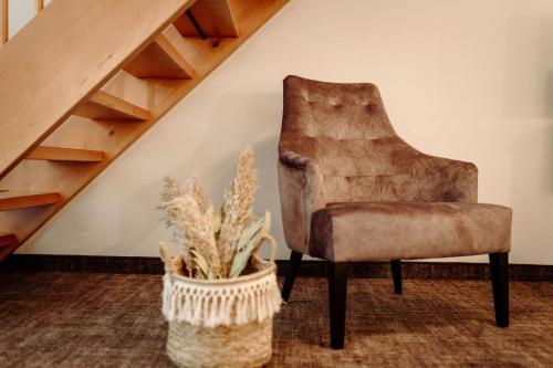 einen Stuhl neben einer Treppe mit Topfpflanze in der Unterkunft Hotel Alte Post in Großarl