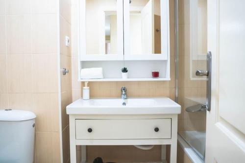 uma casa de banho com um lavatório, um espelho e um WC. em Ap. Benalmádena 2 hab. a 5 minutos de la playa em Benalmádena