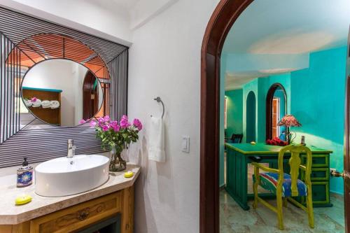a bathroom with a sink and a mirror at Orange Sunsets, Lush Landscape, Intown, Privacy in Puerto Vallarta