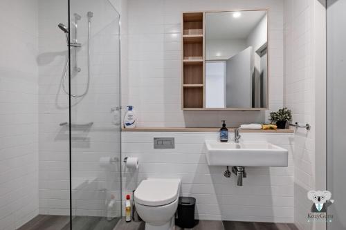a bathroom with a toilet and a sink and a shower at KOZYGURU Penrith Cosy 2BED 2BATH APT + FREE Parking NPE081 in Penrith