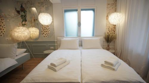 a bedroom with a bed with two towels on it at ConnectIN Apartments in Pale