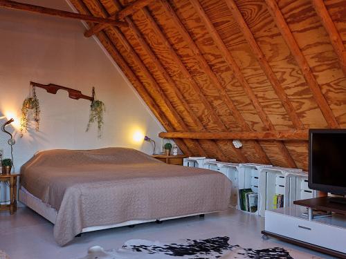 a bedroom with a bed and a wooden ceiling at JagershuisTexel in Oosterend