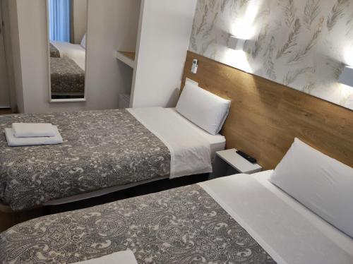 マドリードにあるHostal Esparterosのベッド2台と鏡が備わるホテルルームです。