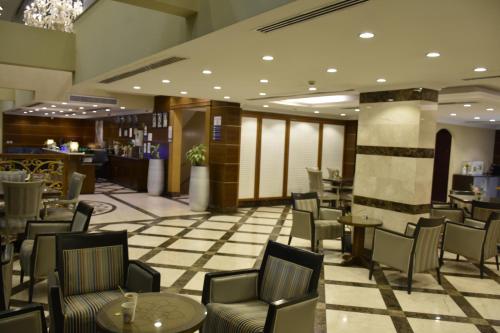 un hall avec des chaises et des tables ainsi qu'un bar dans l'établissement Al Jury Residence Hotel Suites, à Khobar