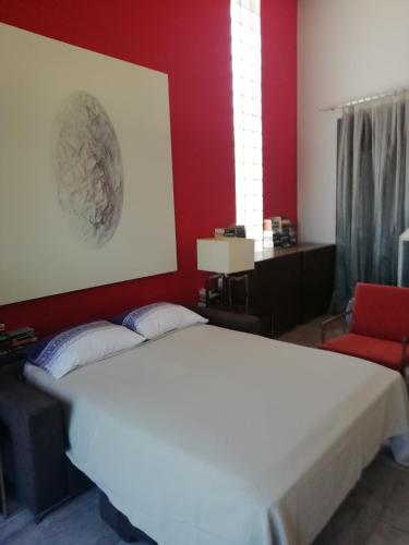 een slaapkamer met een wit bed en een rode muur bij CASA NEUS in El Arrabal de Coll dʼArbós