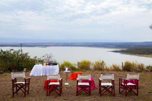 a table and chairs with a view of a lake at Lake Elmenteita Serena Camp in Elmenteita