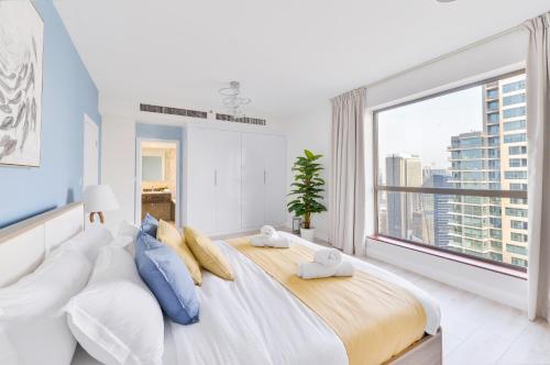 una camera da letto con un grande letto con una grande finestra di Luxury JBR · Marina View · 5* Beach Resorts Access a Dubai