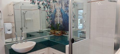 a bathroom with a sink and a shower with a mirror at Potters Place Montville in Montville