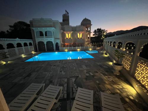 a view of a swimming pool at night at The Kumbha Mahal Resort in Kumbhalgarh