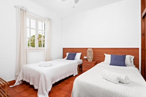 een kamer met 2 bedden en een raam bij Villa etxe txekia in Cala Galdana