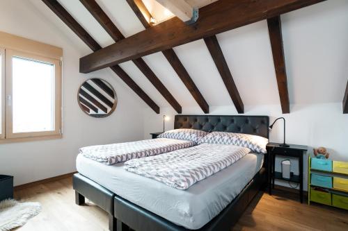 ein Schlafzimmer mit einem Bett in einem Zimmer mit Holzdecken in der Unterkunft Chalet Ruestel in Amden