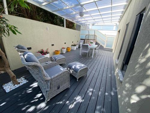 a patio with chairs and a table on a deck at Nichochot Provence in Had Nes
