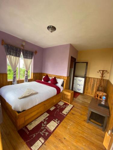 a bedroom with a large bed with red pillows at Gombo Hideaway in Nagarkot