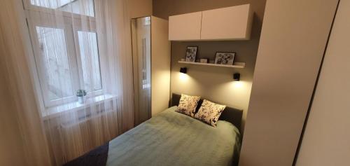 a small bedroom with a bed and a window at CS14 Gold Apartment in Budapest