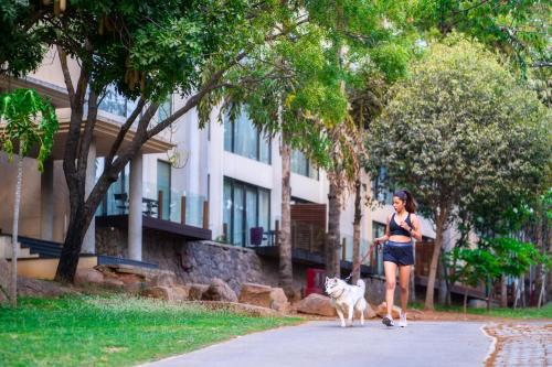 a woman walking a dog on a leash at Hyatt Hyderabad Gachibowli in Hyderabad