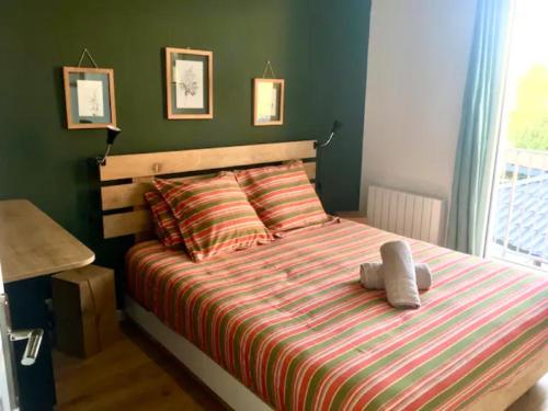 a bedroom with a bed with a striped comforter at T2 stylé/calme et confortable in Arcachon