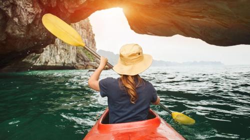 a woman is paddling a kayak in a cave at Holiday Inn Express San Diego - Sorrento Valley by IHG in Sorrento