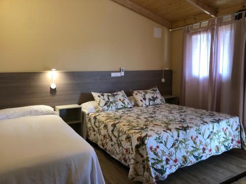ein Hotelzimmer mit 2 Betten und einem Fenster in der Unterkunft Hostal La Posada de Mari in La Cabrera