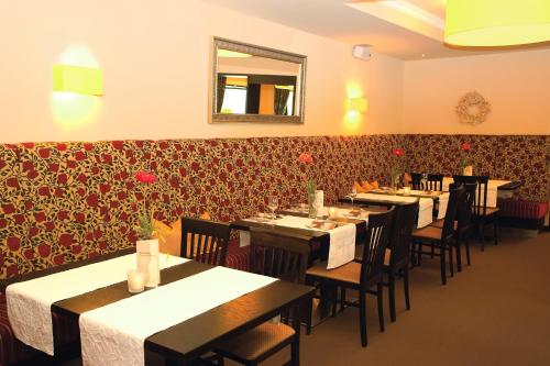a dining room with tables and chairs and a mirror at Moselhotel & Restaurant Zur Traube GmbH in Löf