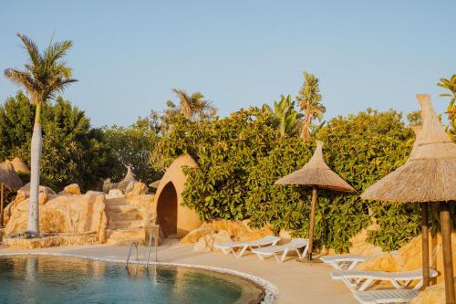 a pool at a resort with chairs and umbrellas at Desert Springs Resort in Vera